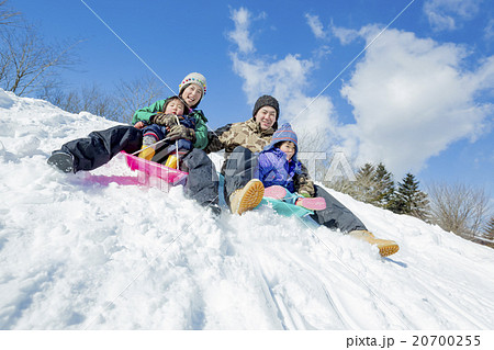 雪の丘でソリ遊びをする4人家族 雪の丘でソリ遊びをする4人家族 20700255