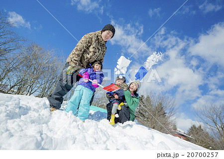 雪の丘で雪を投げて遊ぶ4人家族 20700257