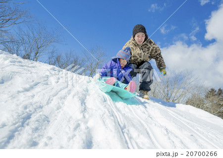 雪の丘でソリ遊びをする父と娘 20700266