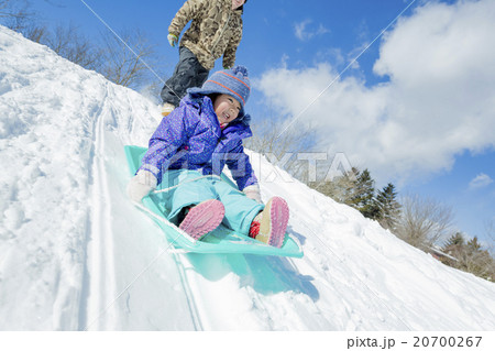 雪の丘でソリ遊びをする父と娘 20700267