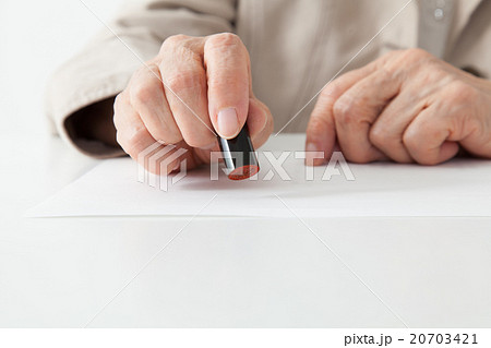 シニア女性 書類に印鑑を押す シニア女性 書類に印鑑を押す 20703421
