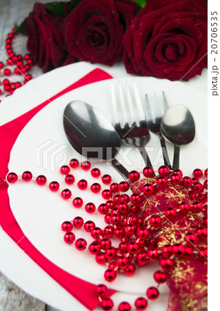 Table setting with red roses on white wood  20706535