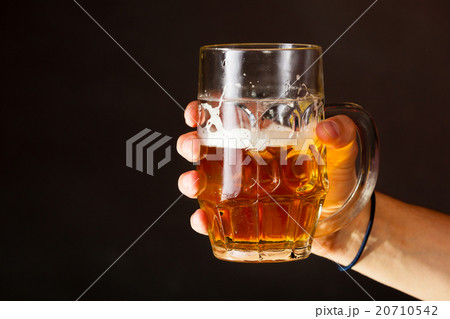 Male hand holding mug of beer 20710542