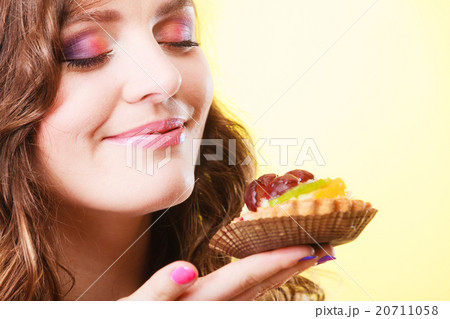 woman closed eyes holds cake in hand 20711058