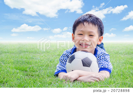 Little Asian boy smiles with his football on field Little Asian boy smiles with his football on field 20728898