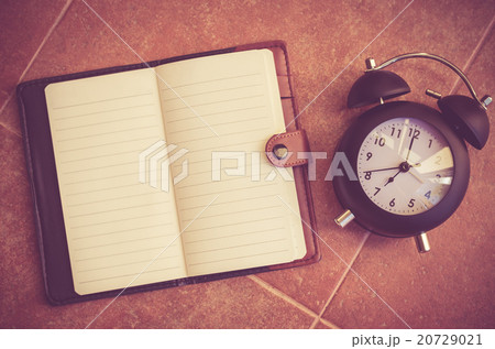 Note book and clock on the floor  20729021