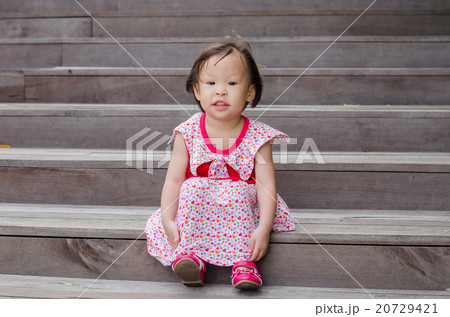 Little Asian girl sitting and smiling outdoor 20729421