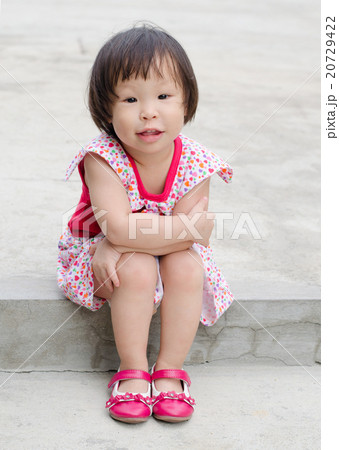 Little Asian girl sitting and smiling outdoor Little Asian girl sitting and smiling outdoor 20729422