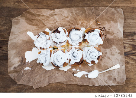 Cinnamon rolls with cream cheese icing on piece of 20735242
