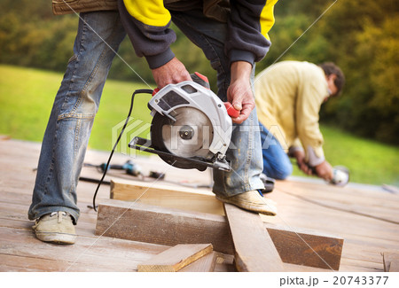 Carpenter grinding wooden planks 20743377