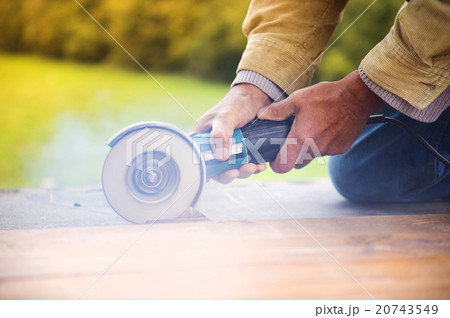 Carpenter grinding wooden planks 20743549