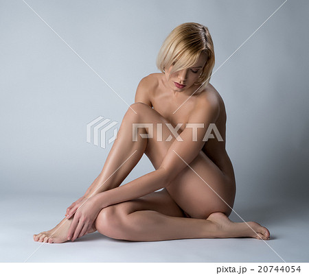 Sexy nude blonde sitting with her head bowed 20744054