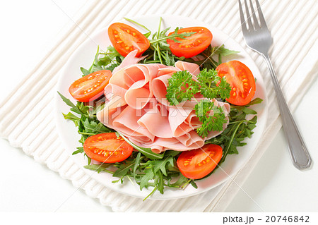 Sliced ham with arugula leaves and tomatoes 20746842