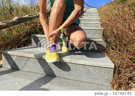 woman trail runner hold her sports injured ankle woman trail runner hold her sports injured ankle 20749745