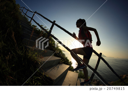 woman trail runner on seaside mountain stairs 20749815