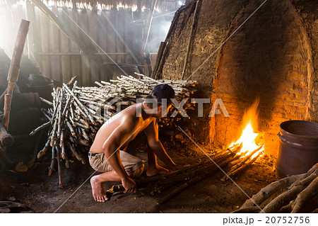 A charcoal worker at work on a  burning wood  20752756