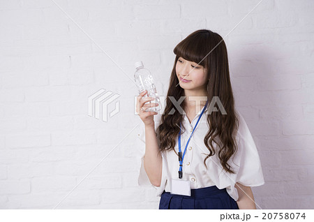 ペットボトルを持つ女性(白いレンガの壁) ペットボトルを持つ女性(白いレンガの壁) 20758074