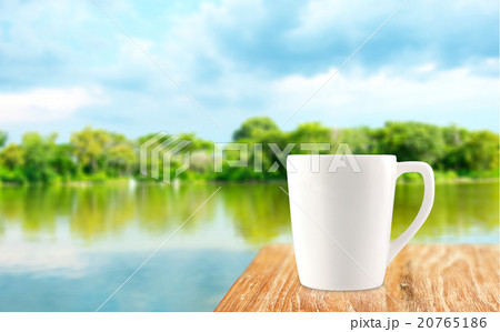 White Coffee cup on wood table at blur tree  20765186
