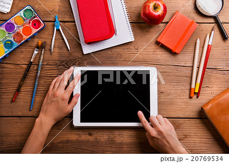 Hands of man with tablet. Various school supplies. Hands of man with tablet. Various school supplies. 20769534