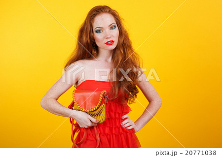 Redheaded pretty girl with orange handbag 20771038