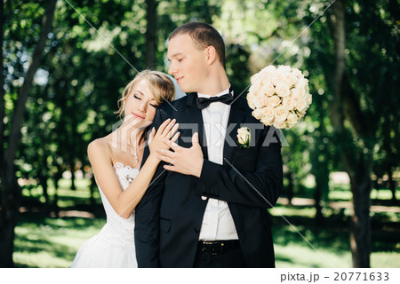 Bride and groom outdoors on a wedding day in park 20771633