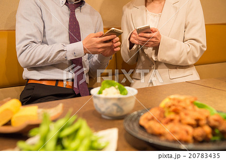 居酒屋で連絡先を交換する男女 20783435