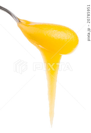 yellow honey flows down from metal spoon close up 20785951