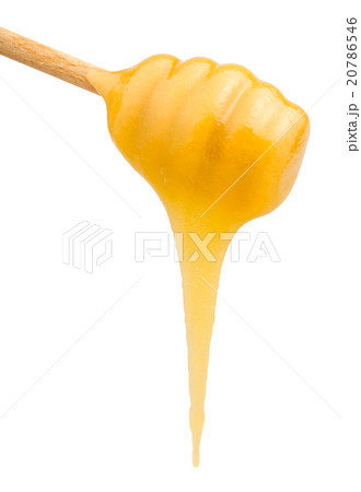 yellow honey flows down from wooden spoon close up 20786546