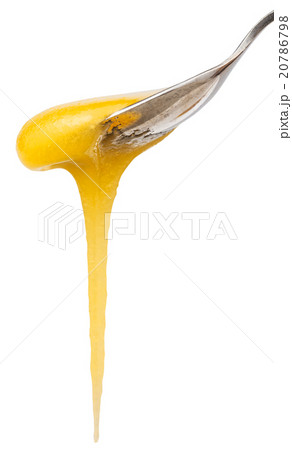 yellow honey flows down from teaspoon close up 20786798