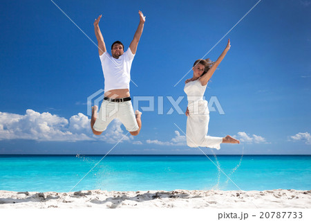 Happy newlyweds jumping up on beach Happy newlyweds jumping up on beach 20787733