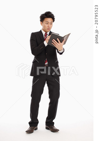 手帳を見て驚くビジネスマン 手帳を見て驚くビジネスマン 20795523