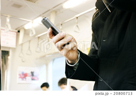電車内でスマホを操作する若い男性 20800713