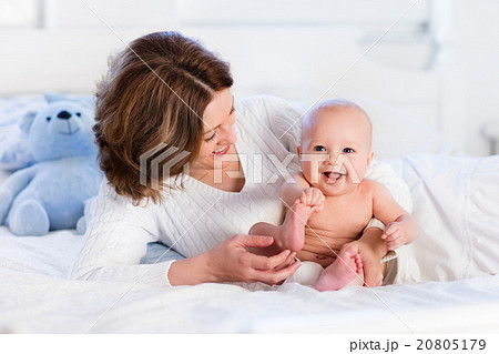 Mother and baby on a white bed 20805179