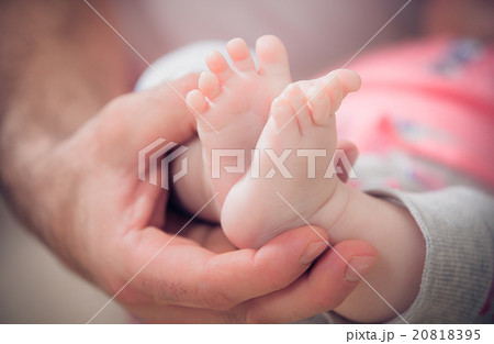 newborn baby feet in male hands 20818395