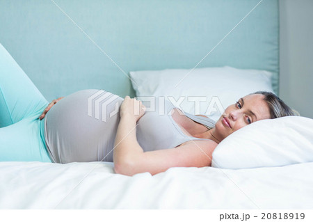 Pregnant woman lying on her bed Pregnant woman lying on her bed 20818919