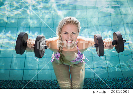 Attractive woman lifting dumbbells Attractive woman lifting dumbbells 20819005