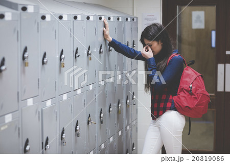 Stressed student beside her locker 20819086