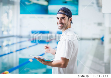 Smiling trainer holding clipboard Smiling trainer holding clipboard 20819433