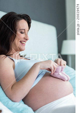 Pregnant woman with knitted slippers on her belly Pregnant woman with knitted slippers on her belly 20819474