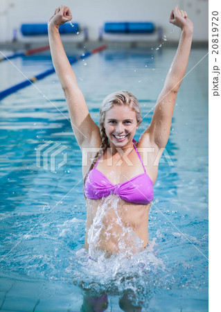 Pretty woman triumphing with raised arms 20819720