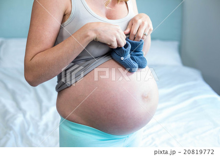Pregnant woman with knitted slippers on her belly 20819772