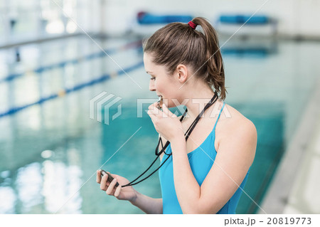 Pretty trainer blowing whistle and looking at stopwatch 20819773