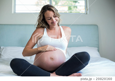 Pregnant woman resting on her bed 20820160