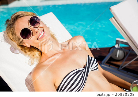 Smiling blonde lying on deck chair 20820508