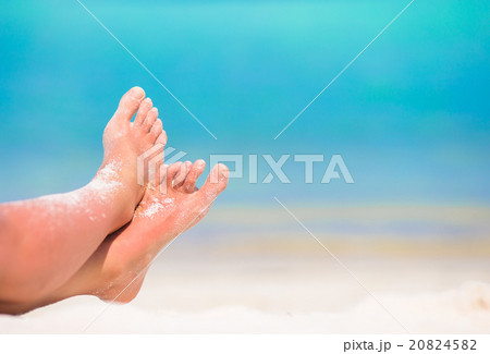 Close up of female feet on white sandy beach 20824582