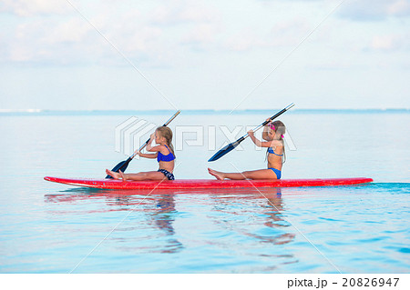 Little girls swimming on surfboard during summer Little girls swimming on surfboard during summer 20826947