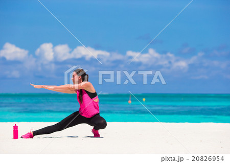 Fit young woman doing exercises on tropical white 20826954