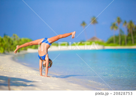 Adorable little girl having fun making cartwheel 20828753