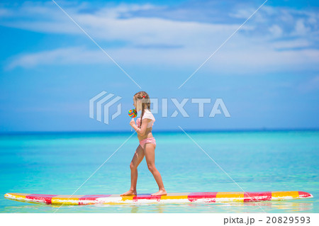 Little girl with lollipop have fun on surfboard in Little girl with lollipop have fun on surfboard in 20829593