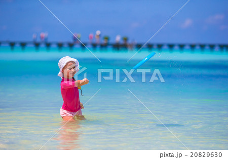 Little girl playing with flying disc at wnite Little girl playing with flying disc at wnite 20829630